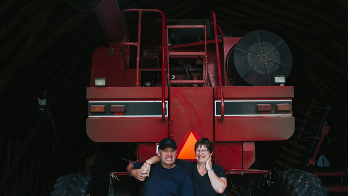 couple standing in front of tractor