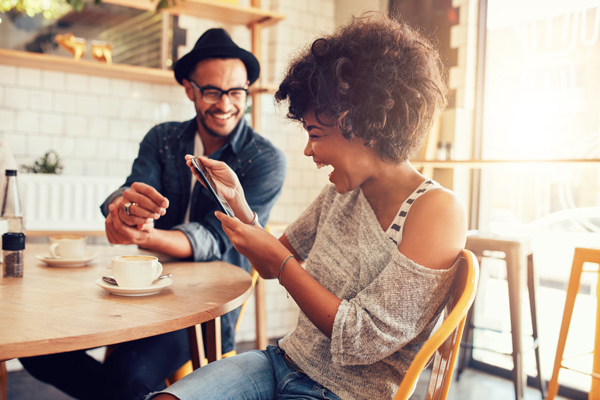 woman and man at a table looking at a device