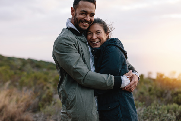 couple outdoors holding each other smiling