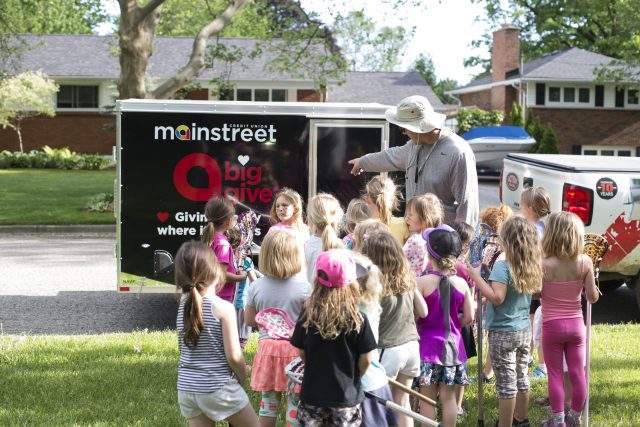 Brian with lacrosse team, outside, standing in front of a trailer near the street