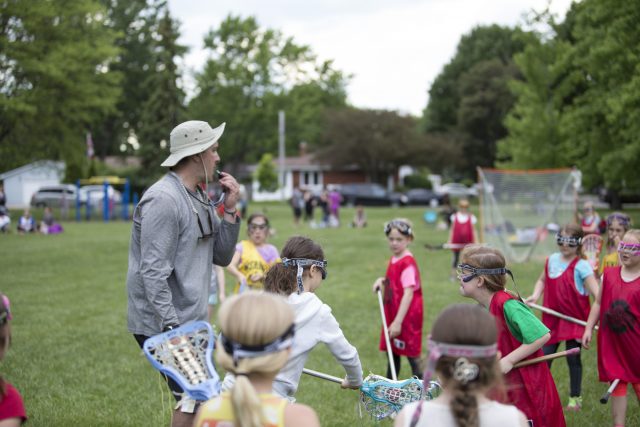 Brian blowing a whistle during a lacrosse game on the field