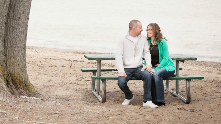 couple sitting at picnic table on the beach