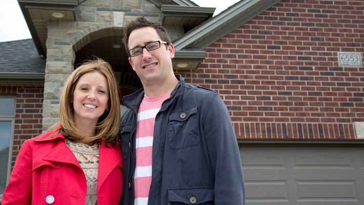 couple standing outside of their home