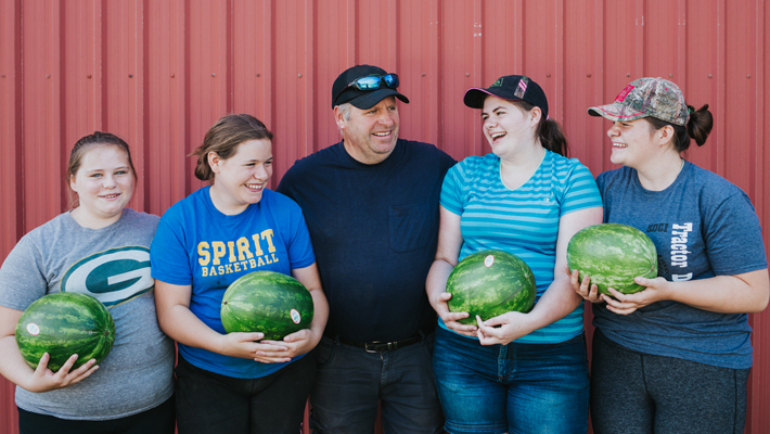 family holding watermelons